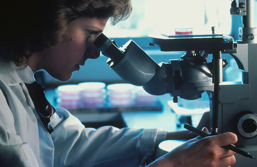 Lab scientist examining a sample under a microscope